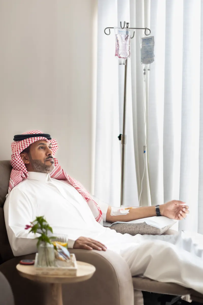 A client resting in a recliner while receiving an intravenous drip