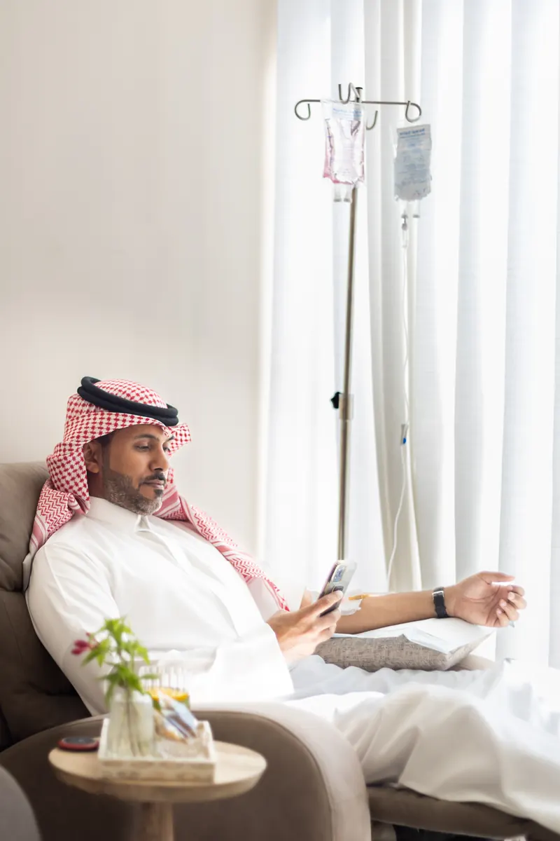 عميل يجلس على كرسي مريح أثناء جلسة محلول وريدي