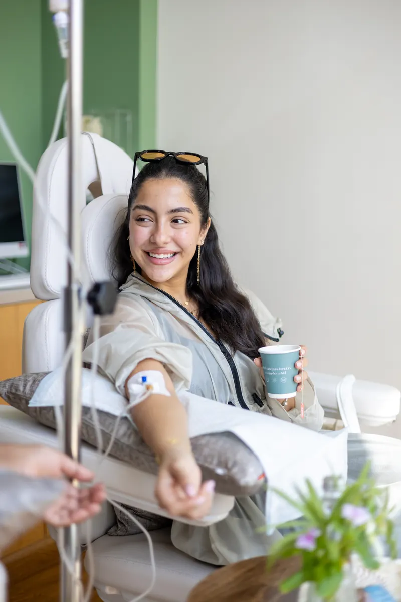 A smiling client receiving an intravenous drip at Effect Doctors London