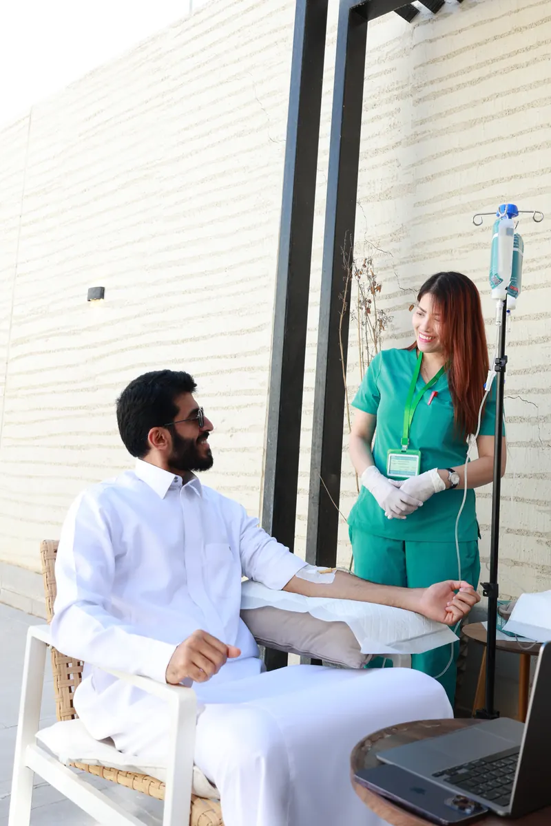 ممرضة تطمئن على عميل أثناء جلسة محلول وريدي