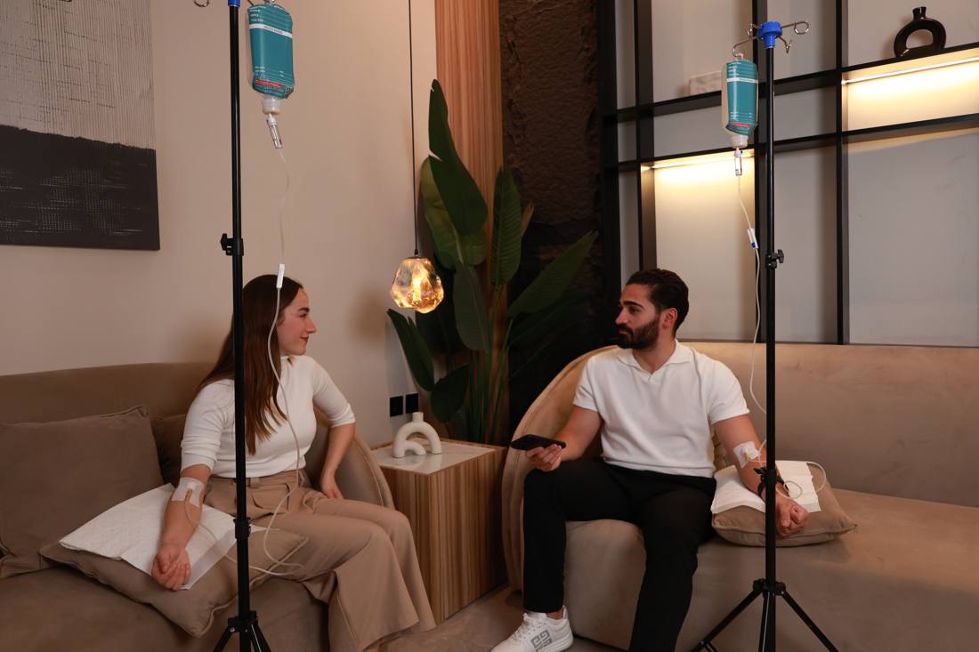 Two patients during their IV drip sessions in the clinic lounge